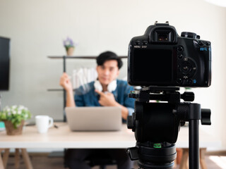 Asian influencer man hold face shield protect covid-19 or coronavirus disease new normal lifestyle advice before start course online broadcast and record by DSLR camera while communicate with student