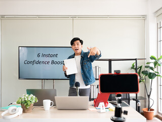 Asian life coach man teaching 6 instant confidence booster for self-esteem improvement broadcast and record video via smartphone while point out finger down for subscribe channel free online tutorial