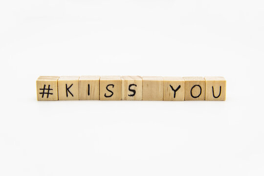 A words KISS YOU  with hashtag. Wooden small cubes with letters isolated on white background with copy space available. Concept image with hashtag.