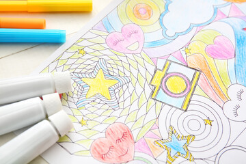 Coloring picture and paints on table, closeup