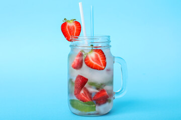 Mason jar of fresh strawberry lemonade on color background