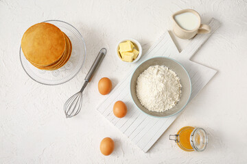 Obraz na płótnie Canvas Tasty pancakes with ingredients on white background