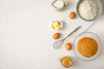 Fototapeta na wymiar Tasty pancakes with ingredients on white background