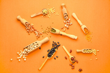 Scoops with raw beans on color background