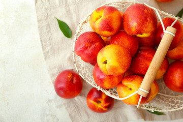 Sweet ripe nectarines in basket on table
