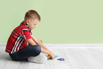 Little boy with autistic disorder near doing puzzle indoors