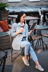 serious businesswoman holding tablet and cofee at city cafe - 368182384