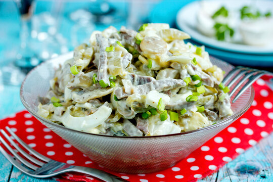 Fried mushroom, meat, onion and egg salad in a glass bowl