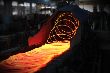 Fototapeta na wymiar Red hot steel metal wire rods or coils after molten steel casting. Continuous casting machine. Background of the blacksmith and metallurgical industry.