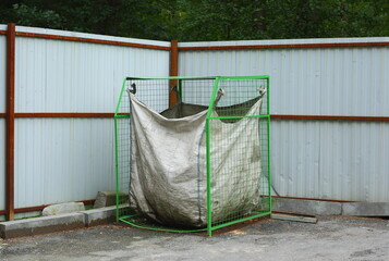 Green metal container with a bag for collecting used plastic bottles