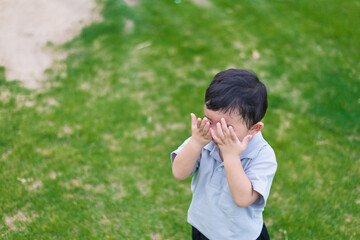 Fototapeta premium Little Asian kid at the playground under the sunlight, shallow DOF