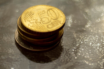 Stack of euro coins on a dark shiny glass table