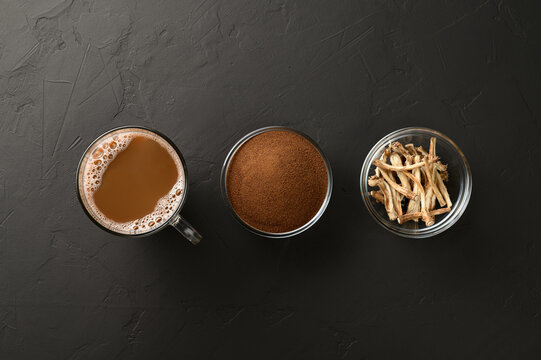 Alternative to coffee. Healthy drink chicory. Chicory coffee in a cup, roots and powder in bowls on a black background. Top view, space for text.