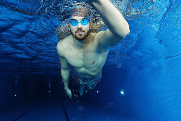 Handsome young man in the swimming pool swimming