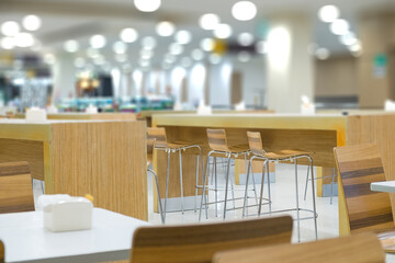 Interior of white table and wooden table on food court in shopping mall.