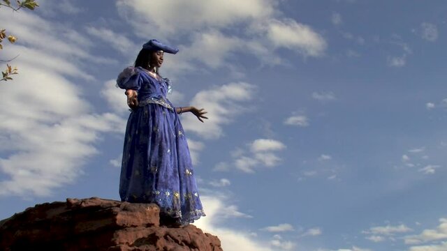 herero woman wearing a Victorian style dress outdoors in a village in north Botswana