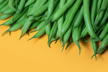Green beans on a yellow background. copy space.