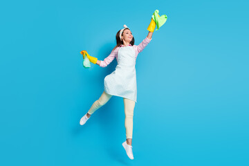 Full length body size view of her she nice attractive cheerful cheery girl maid jumping rubbing wiping glass surface window isolated on bright vivid shine vibrant blue color background