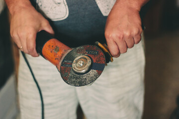 Angular grinding machine in a hands of carpenter.