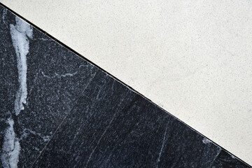 Poor-quality joint of light and dark ceramic floor tiles.Close-up of junction of black and white tiled surfaces.	