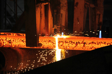 Steel billets at torch cutting in metallurgical plant. Metallurgical production, heavy industry, engineering, steelmaking. - obrazy, fototapety, plakaty