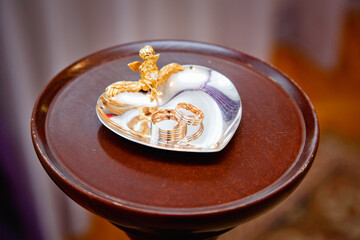 Wedding rings on a golden bowl in a wedding palace. Wedding day of the bride and groom. copy space,