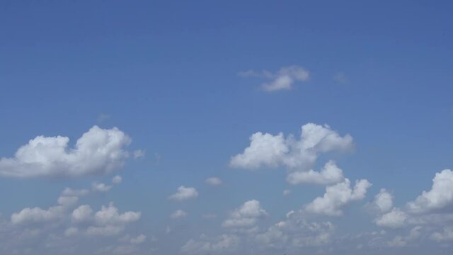 A Quick Time Lapse of White Fluffy Air Clouds in a Light Blue Sky during the Day in Good Weather. Clear Air Space. Atmosphere.