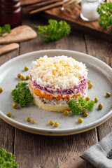 Layer russian salad herring under coat