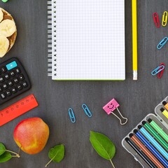 School supplies, sandwich and juice in bottle on chalky background.