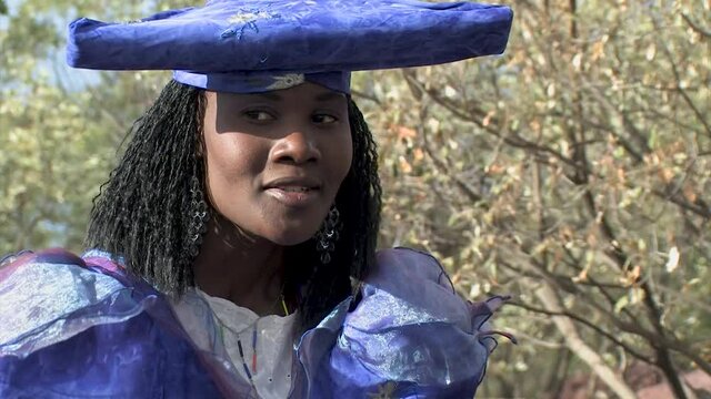 herero woman wearing a Victorian style dress outdoors in a village in north Botswana