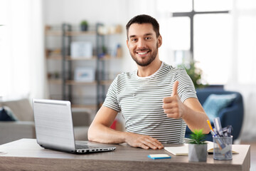 technology, remote job and business concept - happy smiling man with laptop computer showing thumbs up at home office