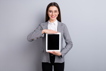 Photo of attractive business lady holding new model digital tablet proposing cool interface many functions low price wear white shirt plaid blazer pants isolated grey color background