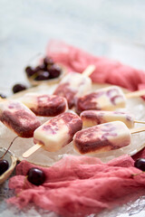 Homemade vegan cherry popsicles with coconut milk. Placed on ceramic plate