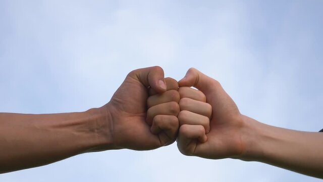 Business concept of teamwork. Close-up of the fists touching the symbol of a successful transaction, cooperation. Two successful people shake hands, a business group handshake.