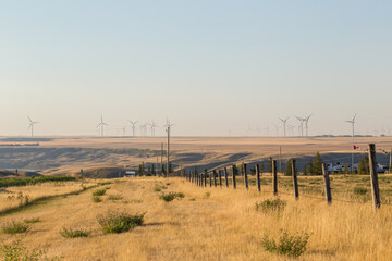Windmill in the distance in Alberta Prairies. Wind farm power as an alternative energy source with...