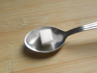 White color granulated Sugar cube on stainless steel spoon