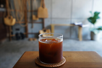 Close up glass of iced black Americano coffee on wooden tray table