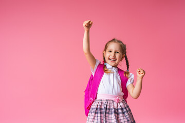 little schoolgirl screams loudly, happy to win on a pink background.