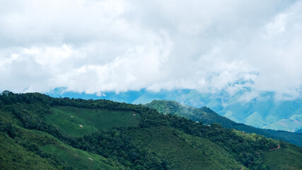 Landscape image of greenery rainforest mountains and hills with cloudy sky
