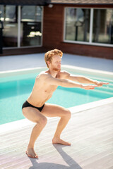 Attractive young man doing sports near pool
