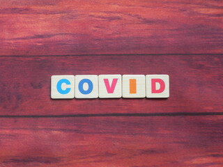 Abbreviation COVID (Coronavirus Disease) on wood background