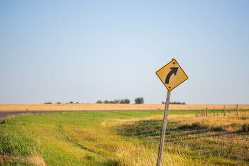 Traffic Signs Right Curve Road Warning and a bend in the highway road shown.. Empty roadway Alberta highway driving along the prairies. Driving symbols