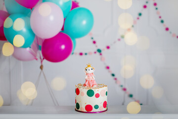 Photo zone with paper garlands, balloons, paper balls, pom poms, confetti and cream cake. Birthday cake. Smash cake. One year
