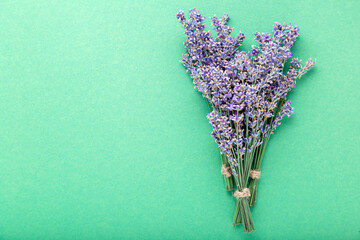 Fresh lavender flower bouquet on color background with copy space. Place for text. Flatlay purple herbal flower blossom. Lavender aromatherapy. Green background