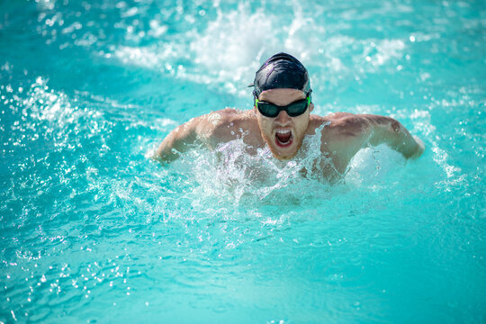 Male swimmer with open mouth arms underwater