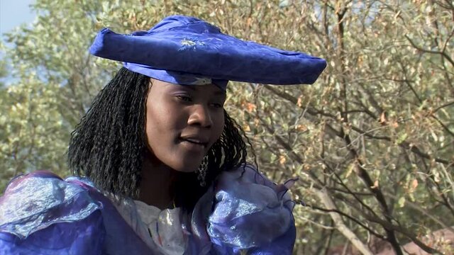herero woman wearing a Victorian style dress outdoors in a village in north Botswana