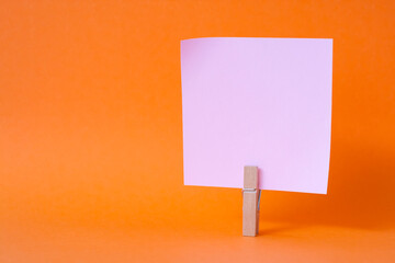 paper notes and clothespins isolated on orange background
