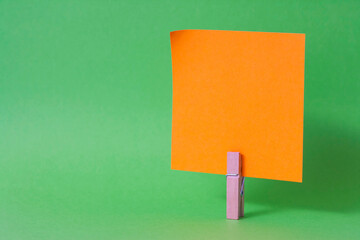 paper notes and clothespins isolated on orange background
