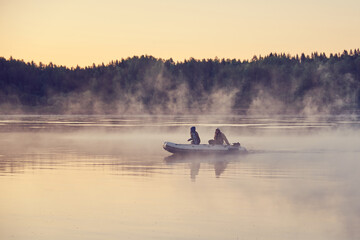 Fishermen on a boat in the morning fog.