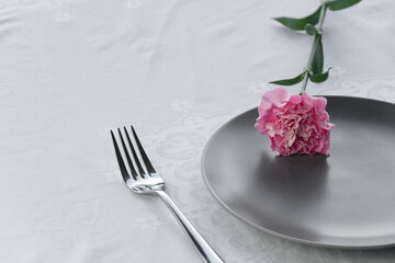 dark grey plate with pink carnation flower for food restaurant service background